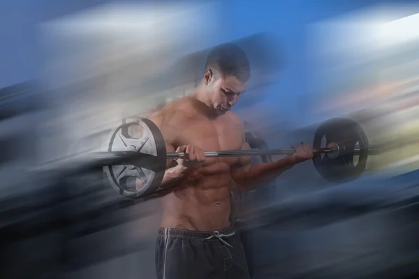 Homem no ginásio exercício bíceps com Barbell — Fotografia de Stock