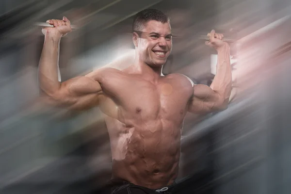 Bodybuilder masculin faisant l'exercice lourd de poids pour des épaules — Photo