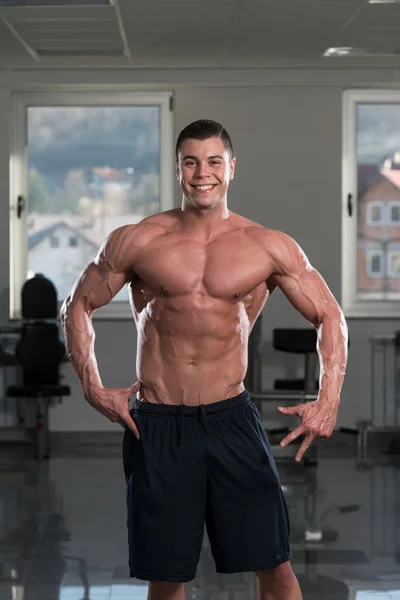 Joven hombre flexión músculos — Foto de Stock