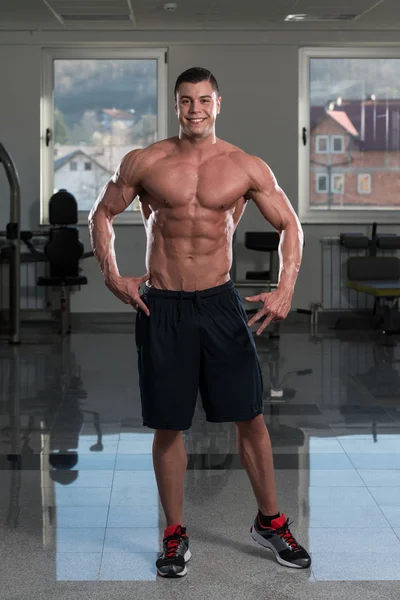 Hombre en el gimnasio mostrando su cuerpo bien entrenado — Foto de Stock