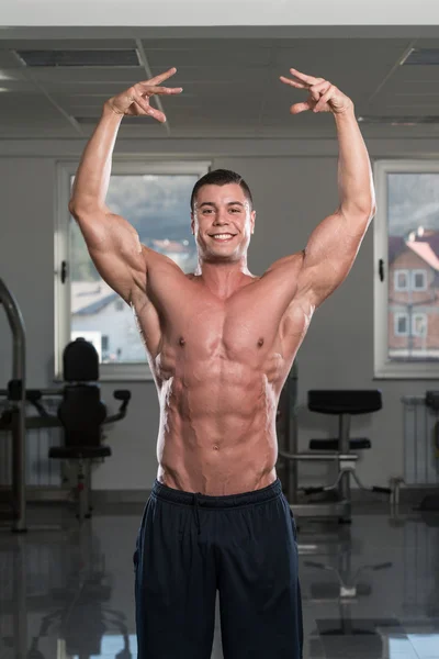 Joven hombre flexión músculos — Foto de Stock