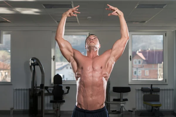 Hombre en el gimnasio mostrando su cuerpo bien entrenado — Foto de Stock