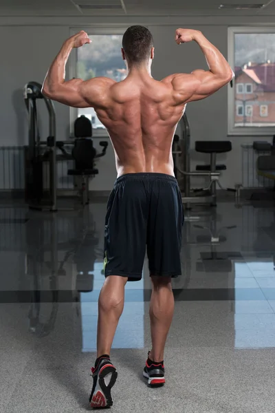 Bodybuilder Performing Rear Double Biceps Pose — Stock Photo, Image