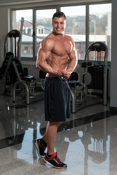 Bodybuilder presterende kant borst vormen — Stockfoto