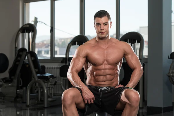 Retrato de un hombre musculoso relajándose en el gimnasio — Foto de Stock