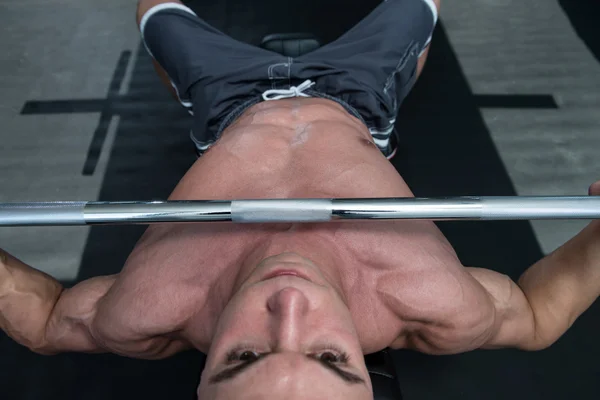 Kaslı adam göğüs için Bench Press egzersiz yaparak — Stok fotoğraf