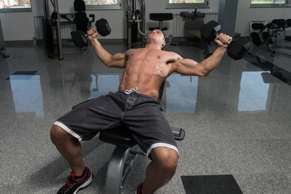 Joven haciendo ejercicio en el pecho con sombrillas — Foto de Stock