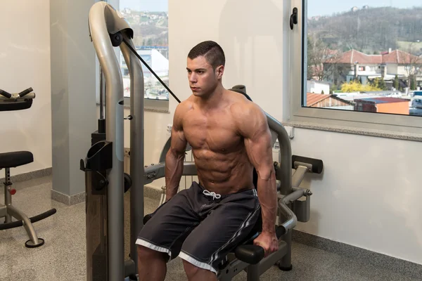 Joven culturista haciendo ejercicio de peso pesado para tríceps — Foto de Stock