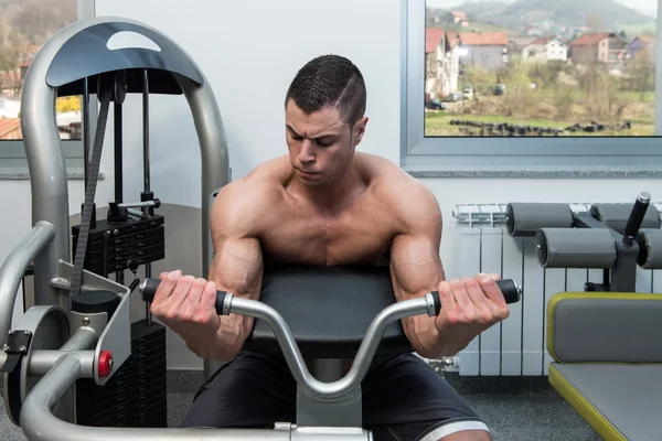 Man In The Gym Exercising Biceps On Machine — Stock Photo, Image
