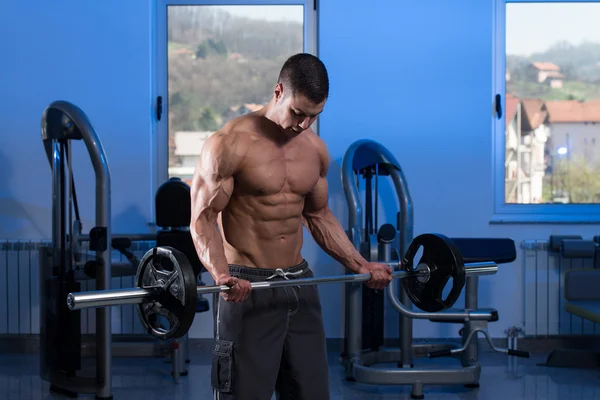 Jovem homem levantando pesos com Barbell — Fotografia de Stock