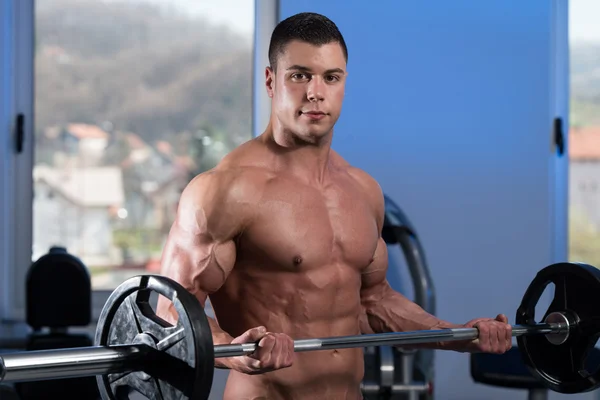 Jovem homem levantando pesos com Barbell — Fotografia de Stock