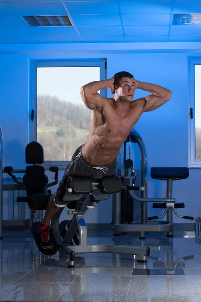 Jeune homme faisant des exercices de dos dans la salle de gym — Photo
