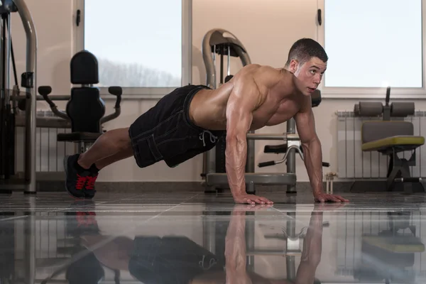 Ung man gör press ups i gym — Stockfoto