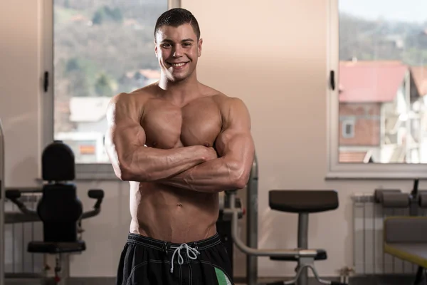 Hombre en el gimnasio mostrando su cuerpo bien entrenado — Foto de Stock