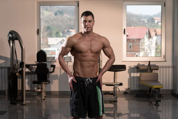 Hombre en el gimnasio mostrando su cuerpo bien entrenado — Foto de Stock