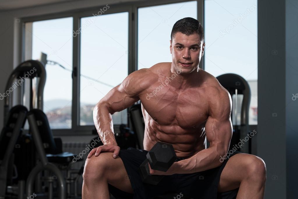 Healthy Young Man Doing Exercise For Biceps