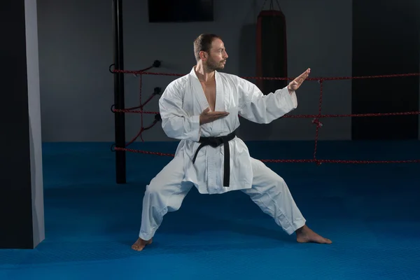 Man In de witte Kimono en zwarte gordel opleiding Karate — Stockfoto