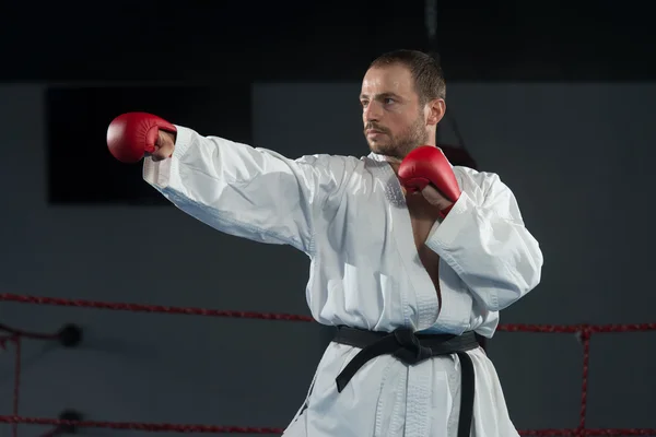 Muž v bílém kimonu a černý pás trénink Karate — Stock fotografie