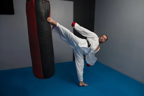 Uomo in kimono bianco e cintura nera formazione karate — Foto Stock