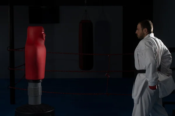 Uomo in kimono bianco e cintura nera formazione karate — Foto Stock