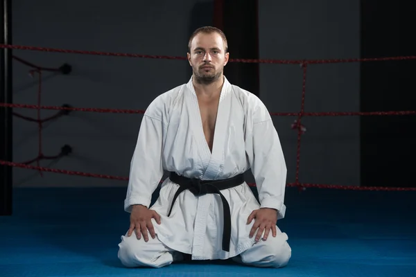 Hombre en un kimono con cinturón negro medita —  Fotos de Stock