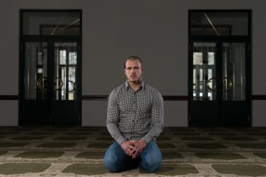 Müslüman adam camide namaz kılıyor.