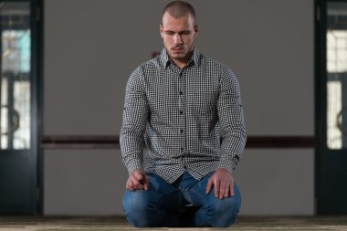 Müslüman adam camide namaz kılıyor.