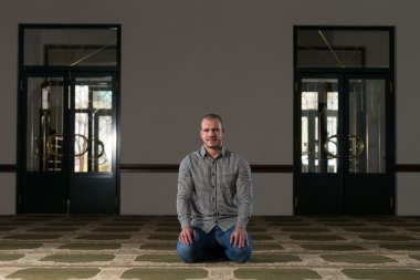 Müslüman adam camide namaz kılıyor.