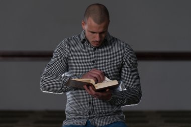 Genç Müslüman adam Kur'an okuma
