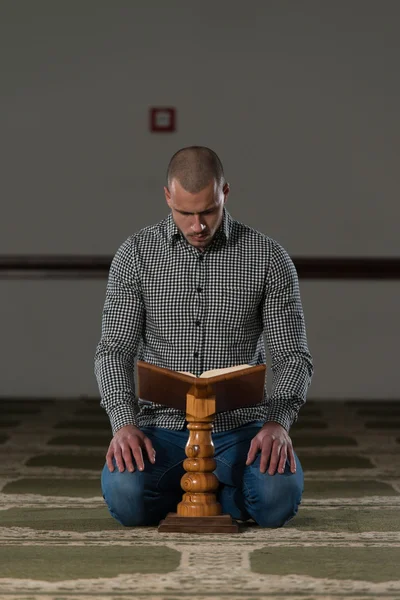 Junger muslimischer Kerl liest den Koran — Stockfoto