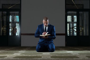 Müslüman işadamı Kur'an okuyor