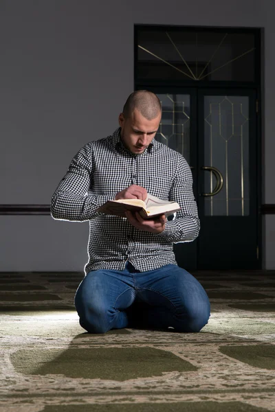 Junger muslimischer Kerl liest den Koran — Stockfoto