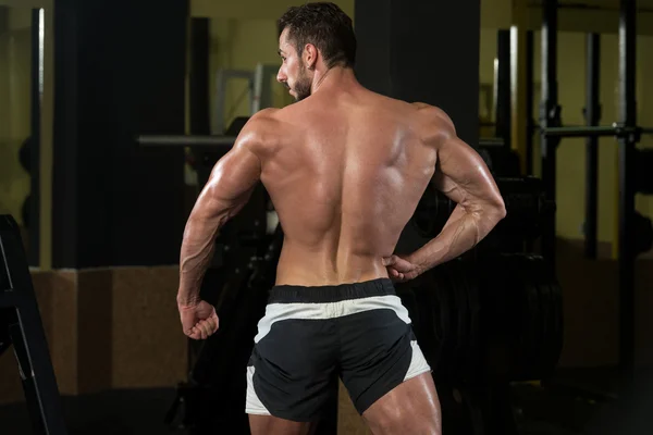 Homme dans la salle de gym montrant son corps bien formé — Photo