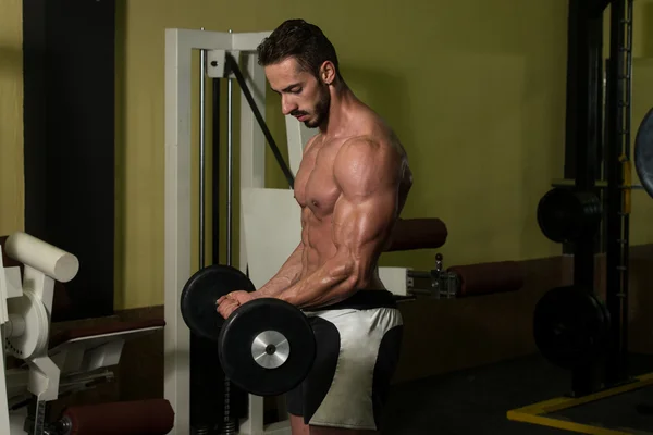 Homem muscular exercitando bíceps com barra — Fotografia de Stock