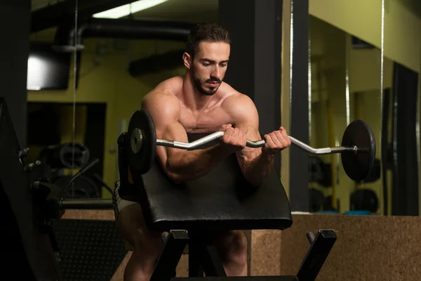 Uomo muscolare che esercita Bicipiti con bilanciere — Foto Stock
