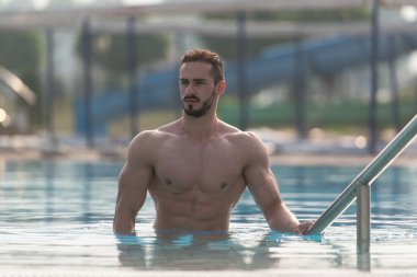 Yüzme havuzunda genç görünen maço adam.