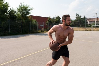 Vücut geliştirmeci basketbol oynarken açık