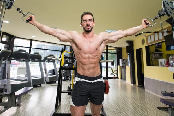 Gespierde bodybuilder presterende kabel crossover — Stockfoto