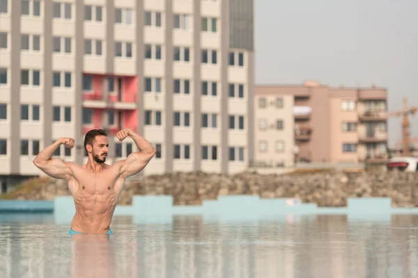 Dobles bíceps posan en la piscina — Foto de Stock