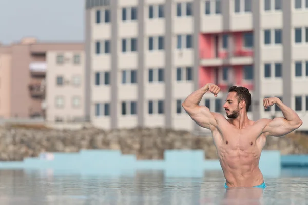 Double pose de biceps dans la piscine — Photo