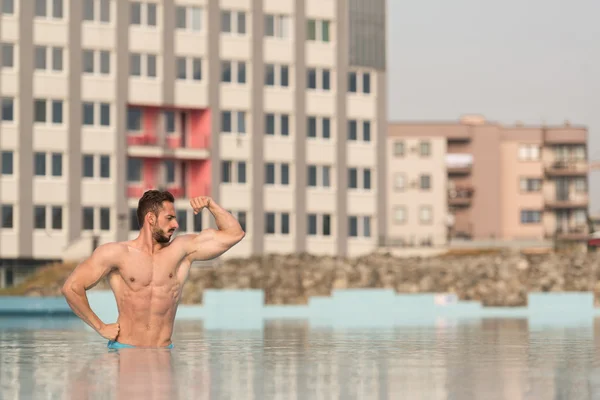 Biceps Pose en la piscina — Foto de Stock