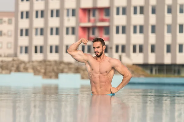 Biceps Pose In The Swimming Pool — Stock Photo, Image