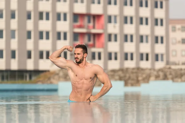 Biceps Pose In The Swimming Pool — Stock Photo, Image