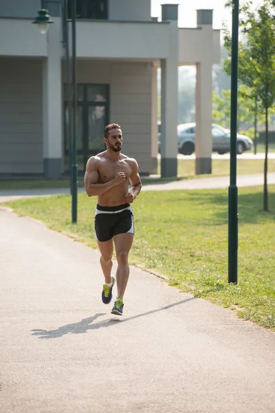 Junger Bodybuilder läuft an einem schönen Tag im Freien — Stockfoto