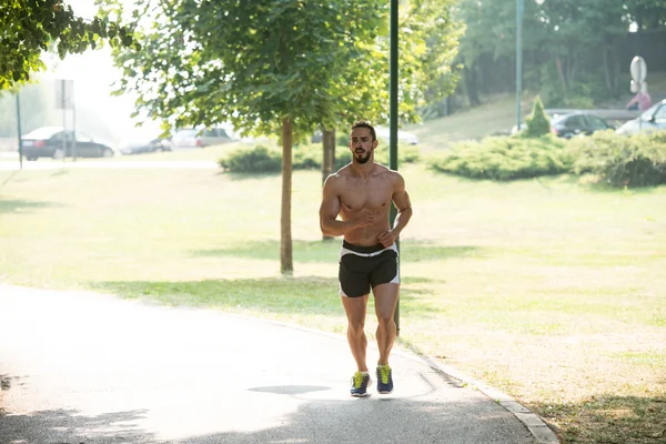 Bodybuilder Runner loopt door het voorjaar Park Road — Stockfoto