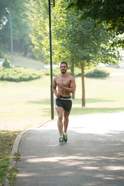 Bodybuilder joggt beim Outdoor-Training im Park — Stockfoto