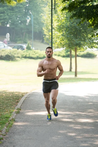 Bodybuilder Runner běží přes Spring Park Road — Stock fotografie