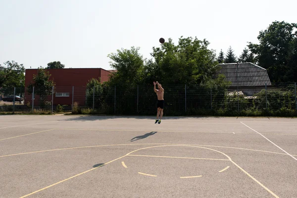 Jogador de basquete atirando em um playground — Fotografia de Stock