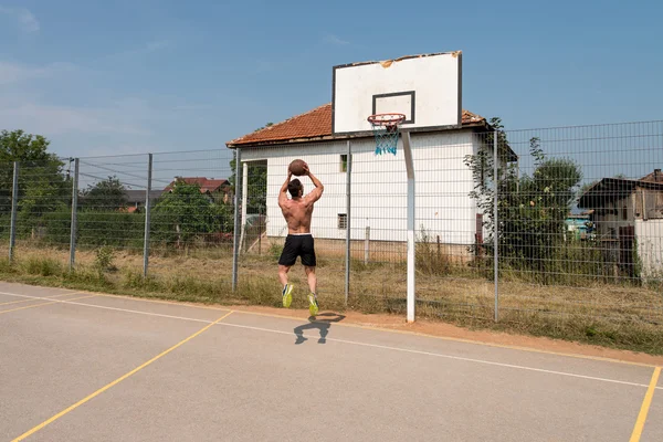 Jugador de baloncesto disparando en un patio de recreo —  Fotos de Stock