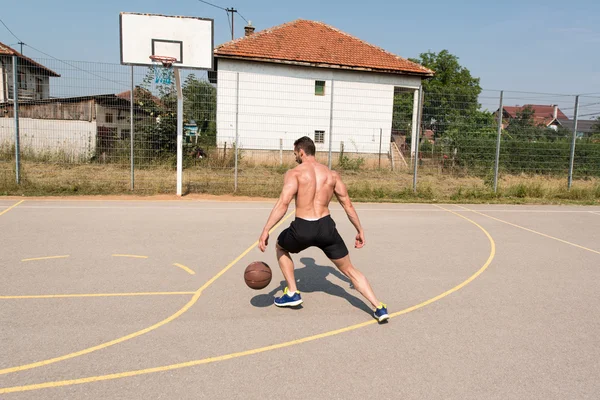 Bodybuilder spielt Basketball im Freien — Stockfoto